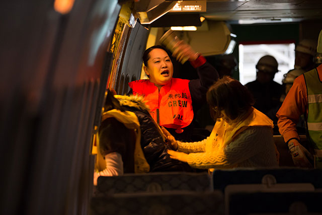 乗客を機外へ誘導する客室乗務員＝2月18日 PHOTO: Tatsuyuki TAYAMA/Aviation Wire