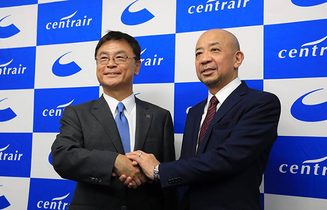 中部国際空港会社の新社長に就任する犬塚氏（右）と握手を交わす友添社長（同社提供） 