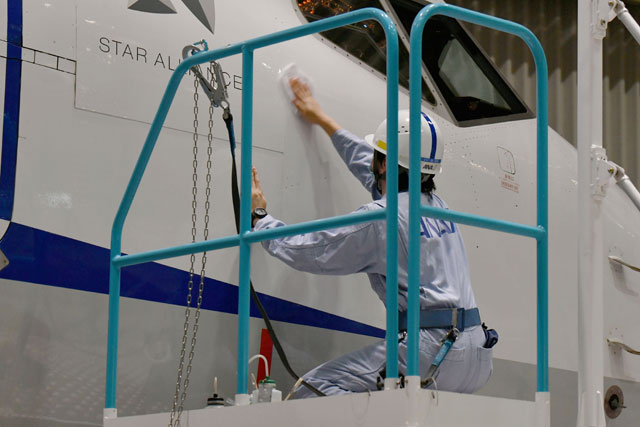 羽田空港の格納庫でANAウイングス創立10周年デカール貼付前に737-800 JA89AN を拭く整備士＝20年9月23日 PHOTO: Tadayuki YOSHIKAWA/Aviation Wire