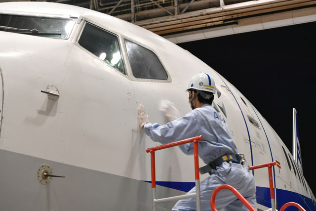 羽田空港の格納庫でデカール貼付前に737-700 JA05AN を拭く整備士＝21年5月10日 PHOTO: Tadayuki YOSHIKAWA/Aviation Wire
